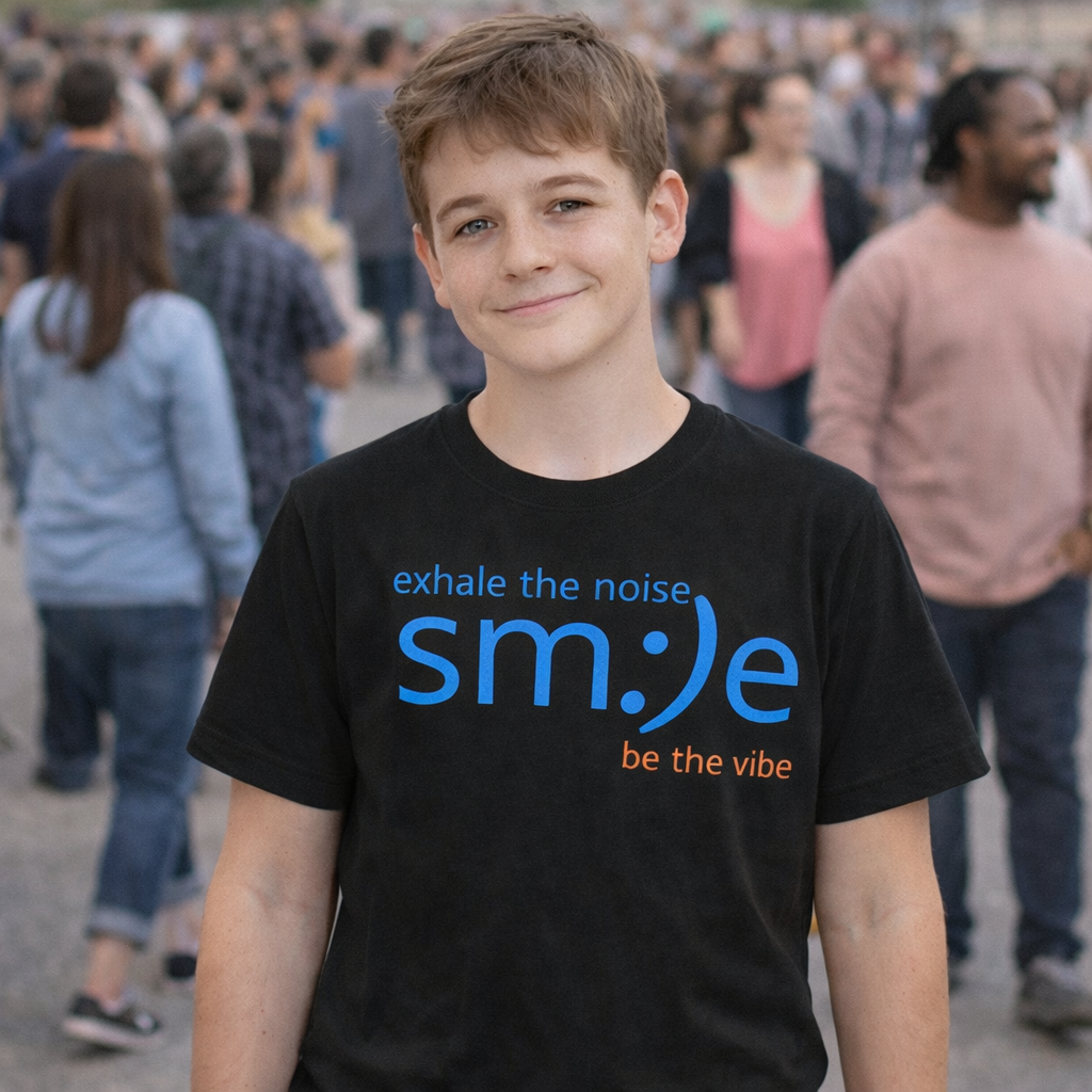 Young boy wearing a black t-shirt with motivational text, standing in a crowd.